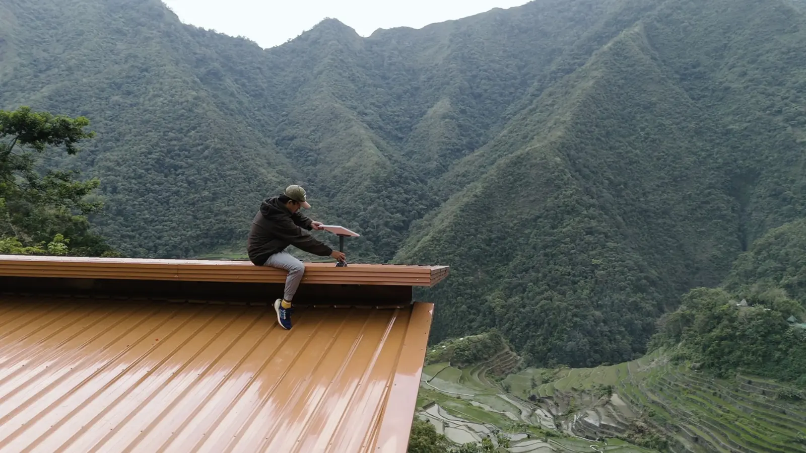 Man installing Starlink satellite antenna on a house roof for internet connectivity